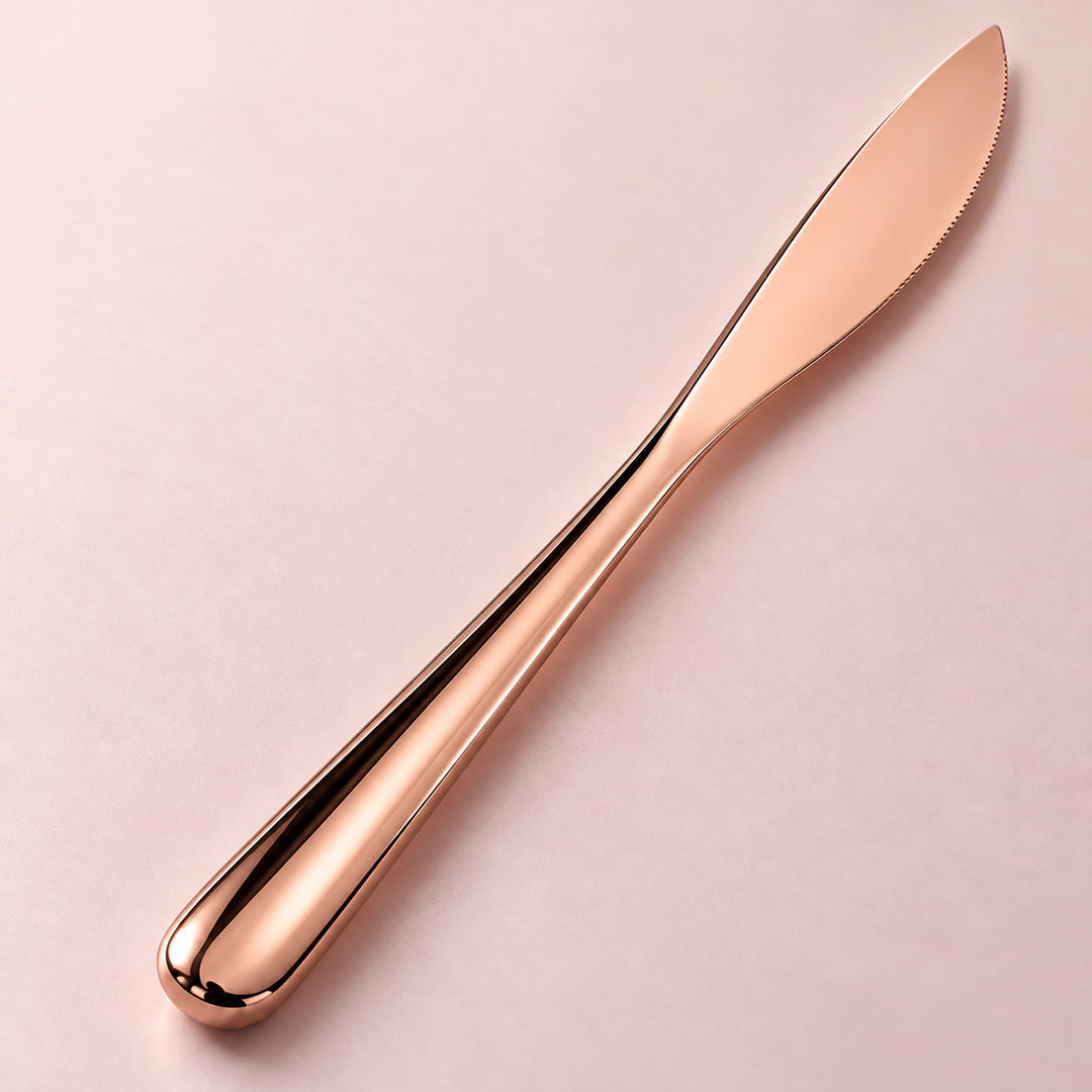 Rose-gold dinner knife smooth metal handle detail.