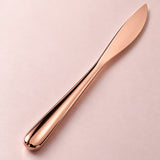 Rose-gold dinner knife smooth metal handle detail.