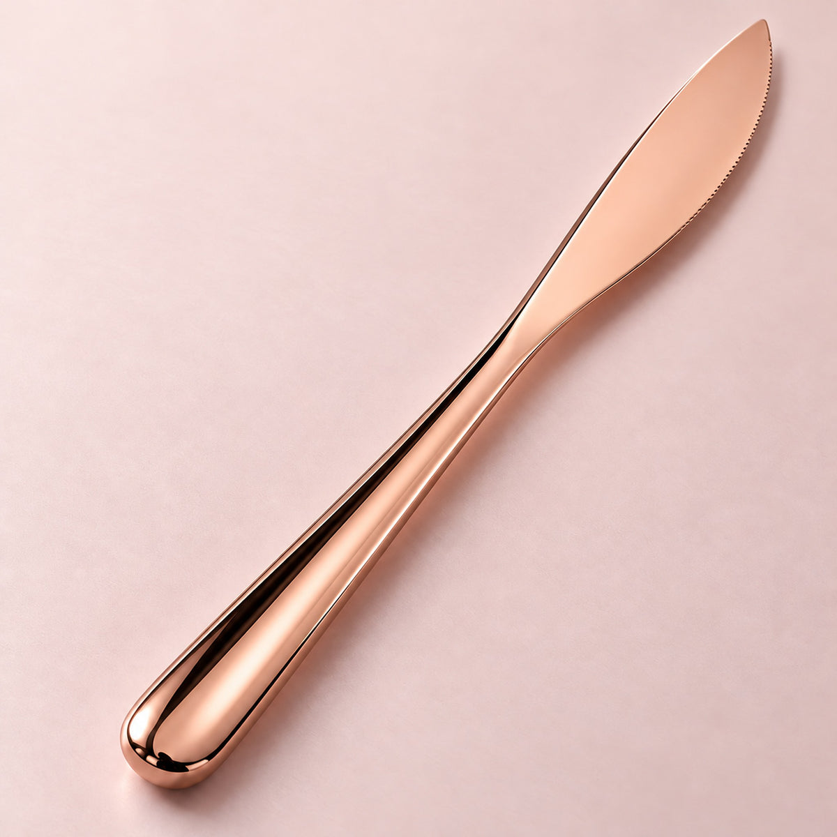 Rose-gold dinner knife smooth metal handle detail.