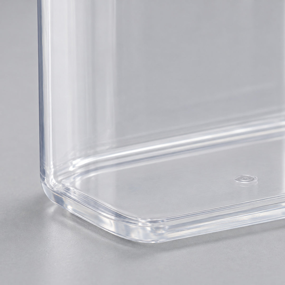 Clear PP plastic wall and molded base corner of the storage container.