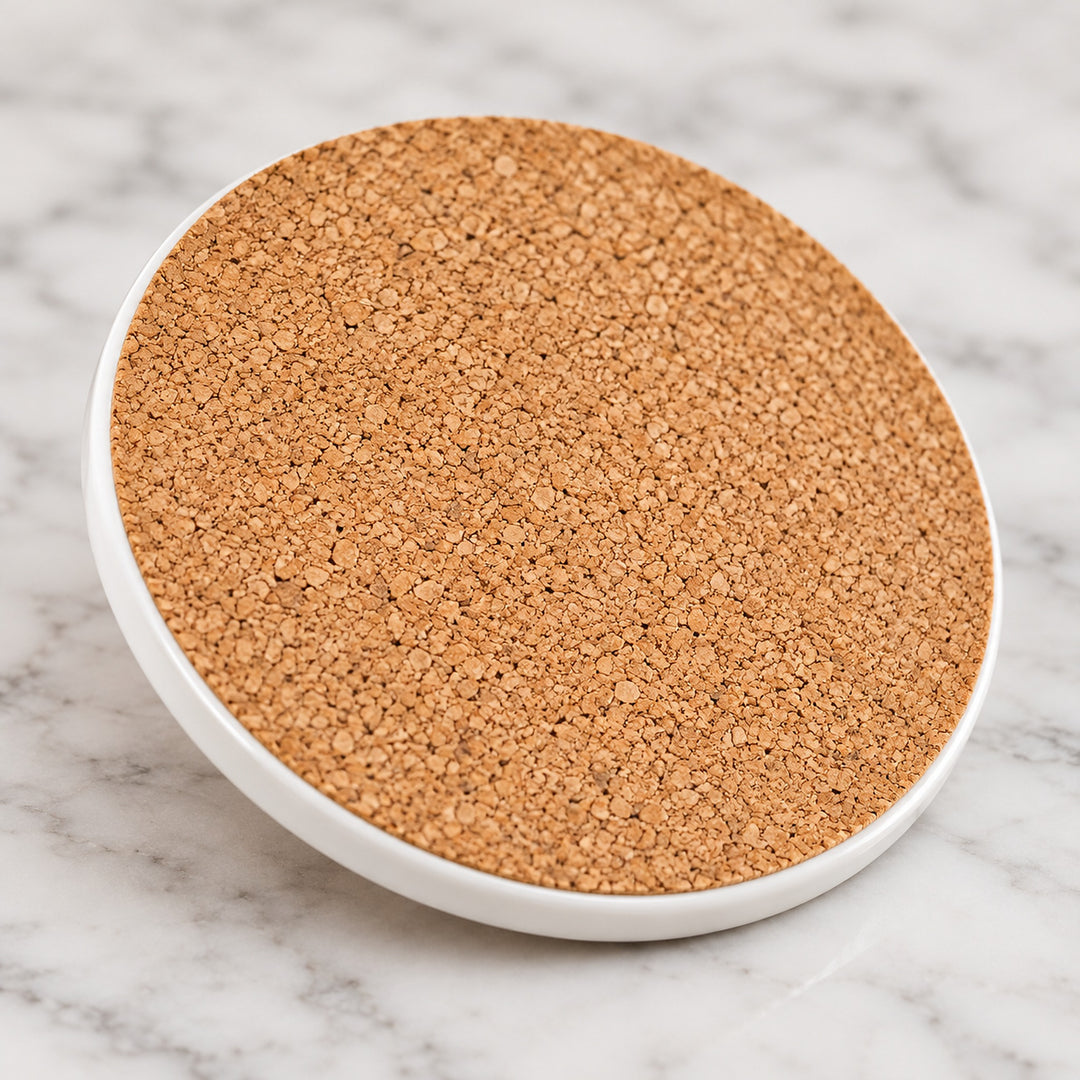 Cork backing and thin ceramic edge of one round coaster.