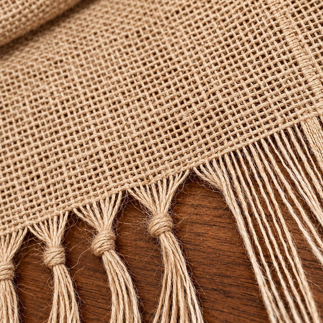 Close-up of coarse woven jute fibers and stitched fringe junction.