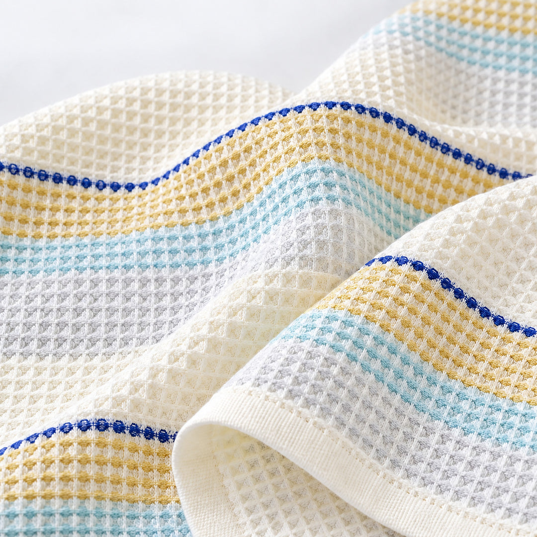 Close-up of woven cotton waffle cells and blue striped hem.
