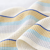 Close-up of woven cotton waffle cells and blue striped hem.