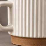 White ribbed glaze meeting the exposed brown ceramic base.