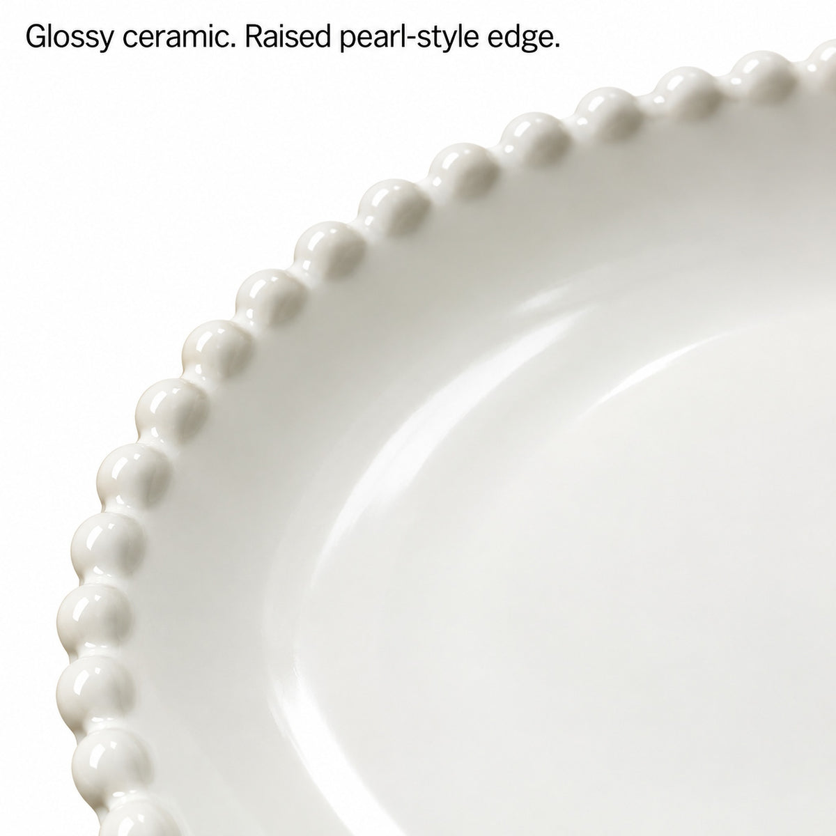 Close-up of glossy white ceramic and the raised pearl-style plate edge.