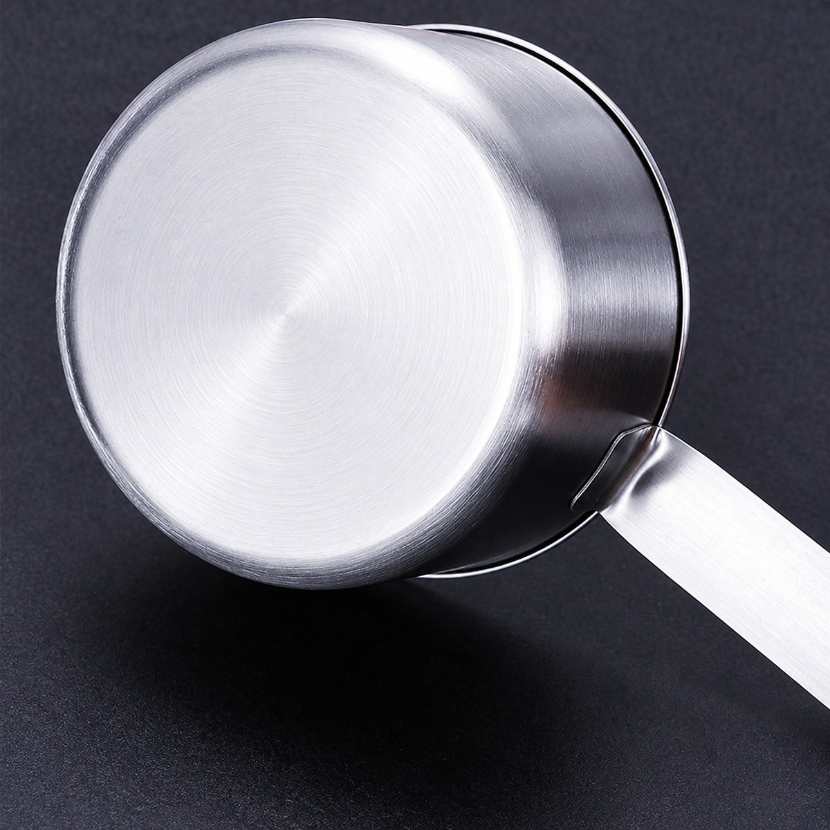 Close-up of the measuring cup brushed stainless steel base and handle attachment.