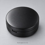 Round case approximately 8 cm in diameter and 3 cm high.