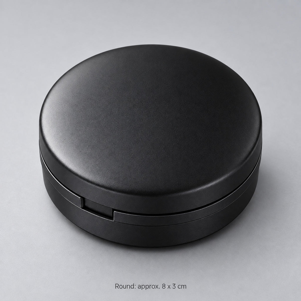 Round case approximately 8 cm in diameter and 3 cm high.