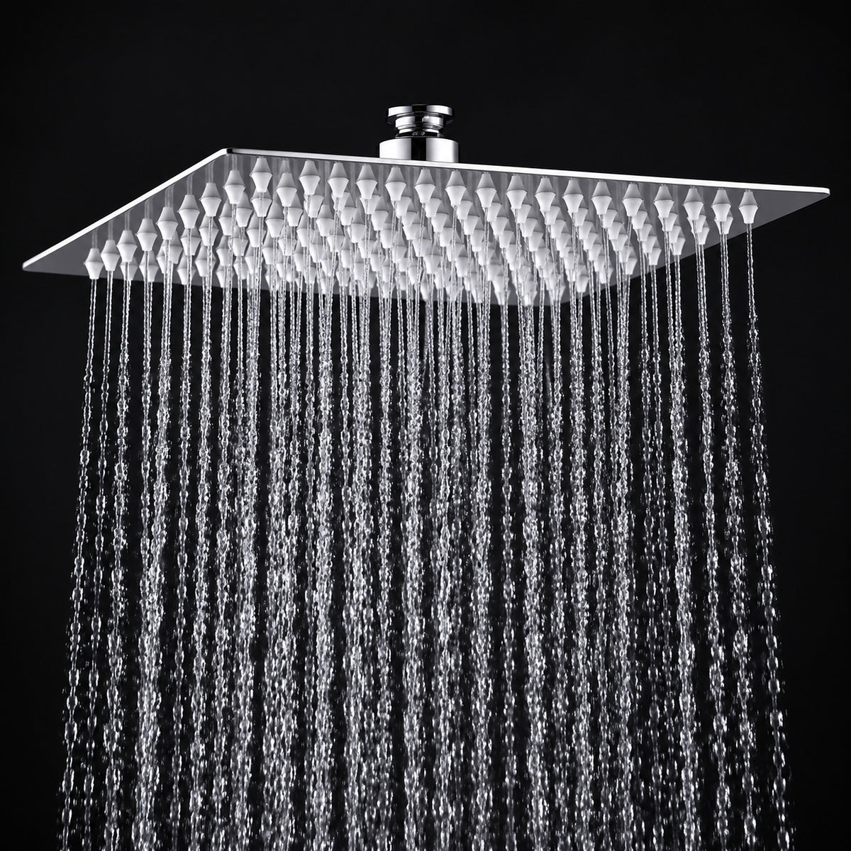 A square rain shower head with a textured chrome finish, shown with water droplets falling from its multiple nozzles against a solid black background.