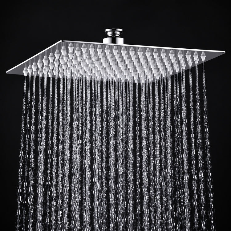 A square rain shower head with a textured chrome finish, shown with water droplets falling from its multiple nozzles against a solid black background.