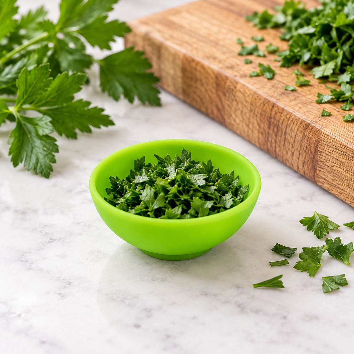Mini silicone bowl holding chopped herbs for food prep.