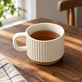 240 ml white ceramic mug holding tea.