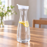 Lidded clear plastic carafe holding cold lemon water.