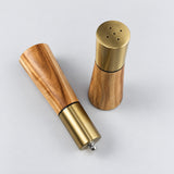 Salt shaker dispensing holes beside the pepper grinder top adjustment nut.
