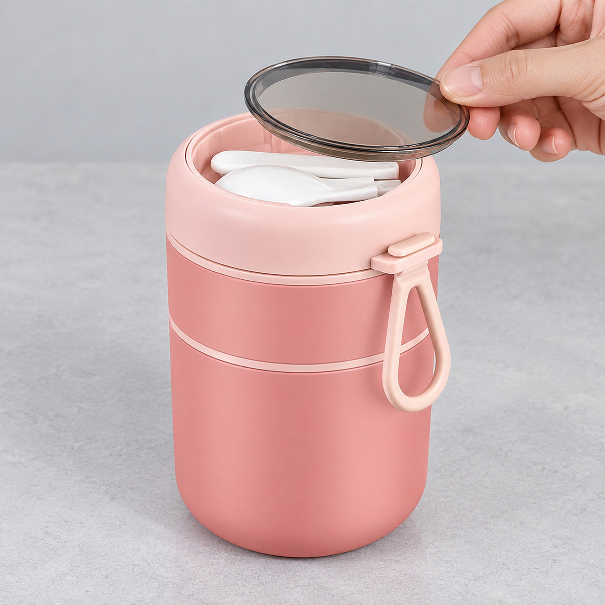 Pink jar's translucent lid disk lifted to reveal utensil storage.