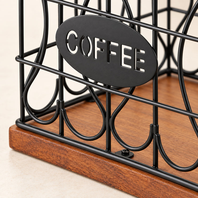 Close-up of a black metal coffee organizer with an oval sign reading COFFEE and a wooden base, shown on a light beige surface.