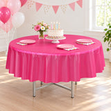 One hot-pink disposable round table cover at a party.