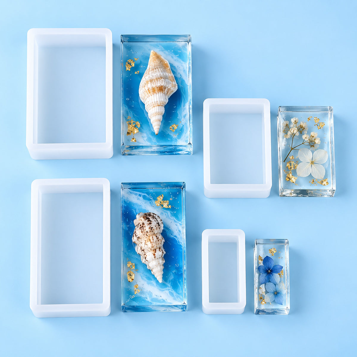 Six rectangular clear resin blocks in different sizes arranged on a light blue background, some empty and others containing decorative seashells, dried flowers, and small gold flakes.