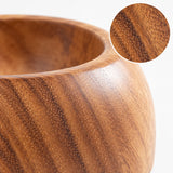 Close detail of smooth acacia wood bowl grain and rounded rim