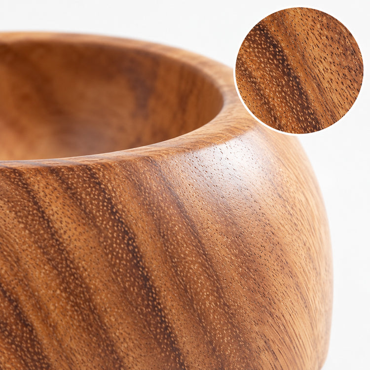 Close detail of smooth acacia wood bowl grain and rounded rim