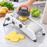 Mandoline preparing crinkle potato slices with the food holder.