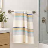 One blue striped cotton waffle towel hanging beside a shower; fixtures not included.
