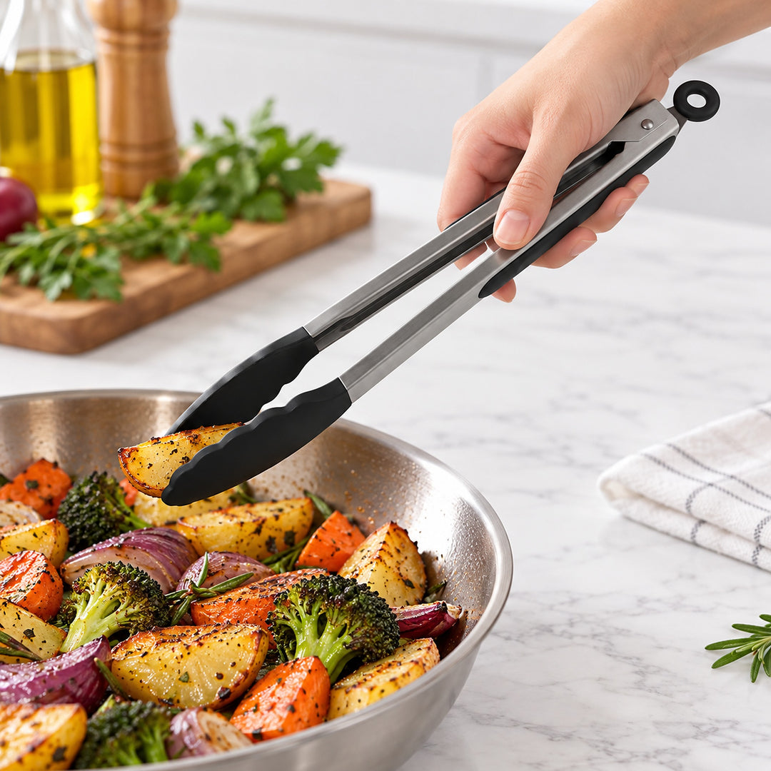 Black 12-inch tongs lifting roasted vegetables.