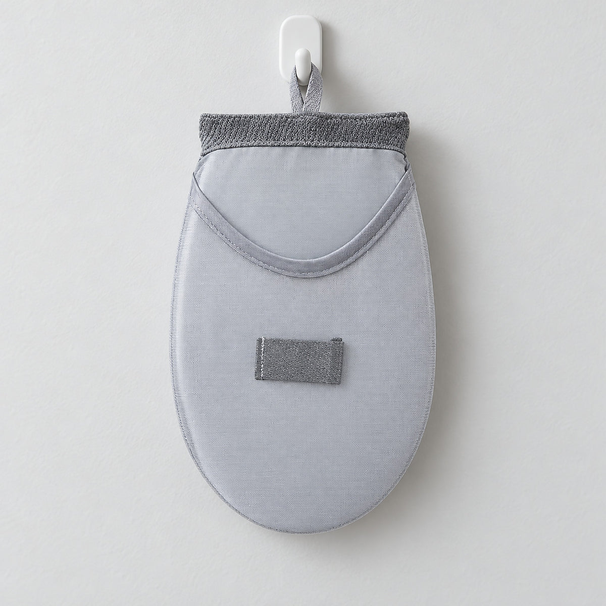Rounded steaming pad stored using its fabric hanging loop.