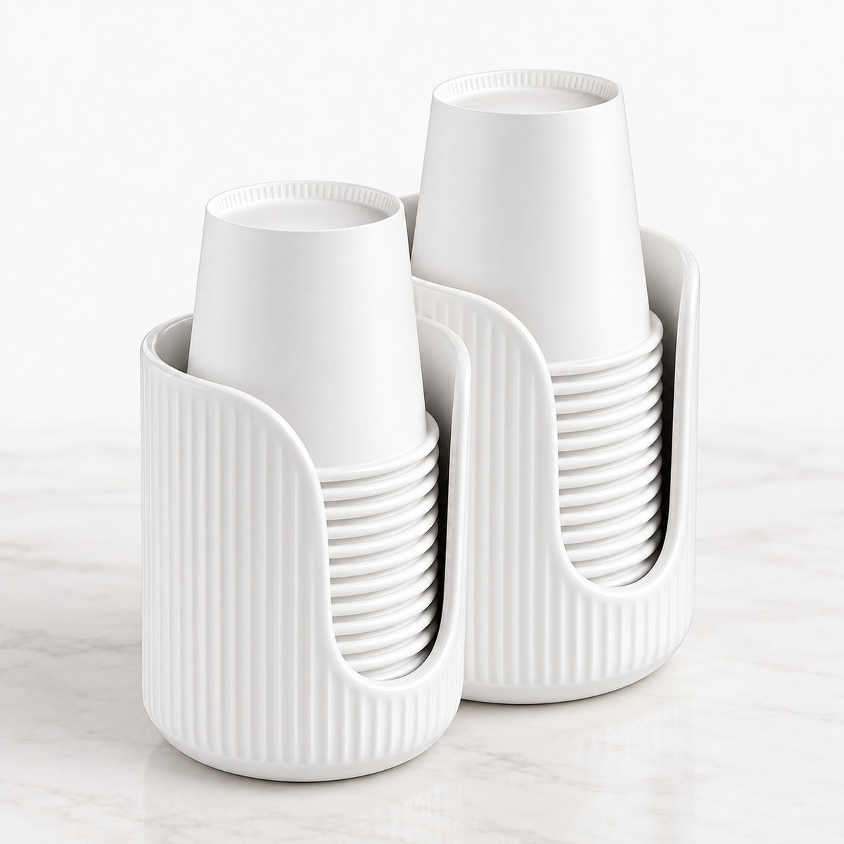 Two white ribbed cup holders on a light marble surface against a white background, each holding a stack of white cups.