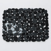 A rectangular arrangement of glossy black pebble-shaped tiles or stones on a plain white background.