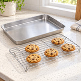 Cookies cooling on the raised wire rack beside its matching tray.