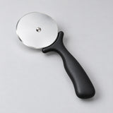 Angled view of the black pizza cutter and thin steel wheel.