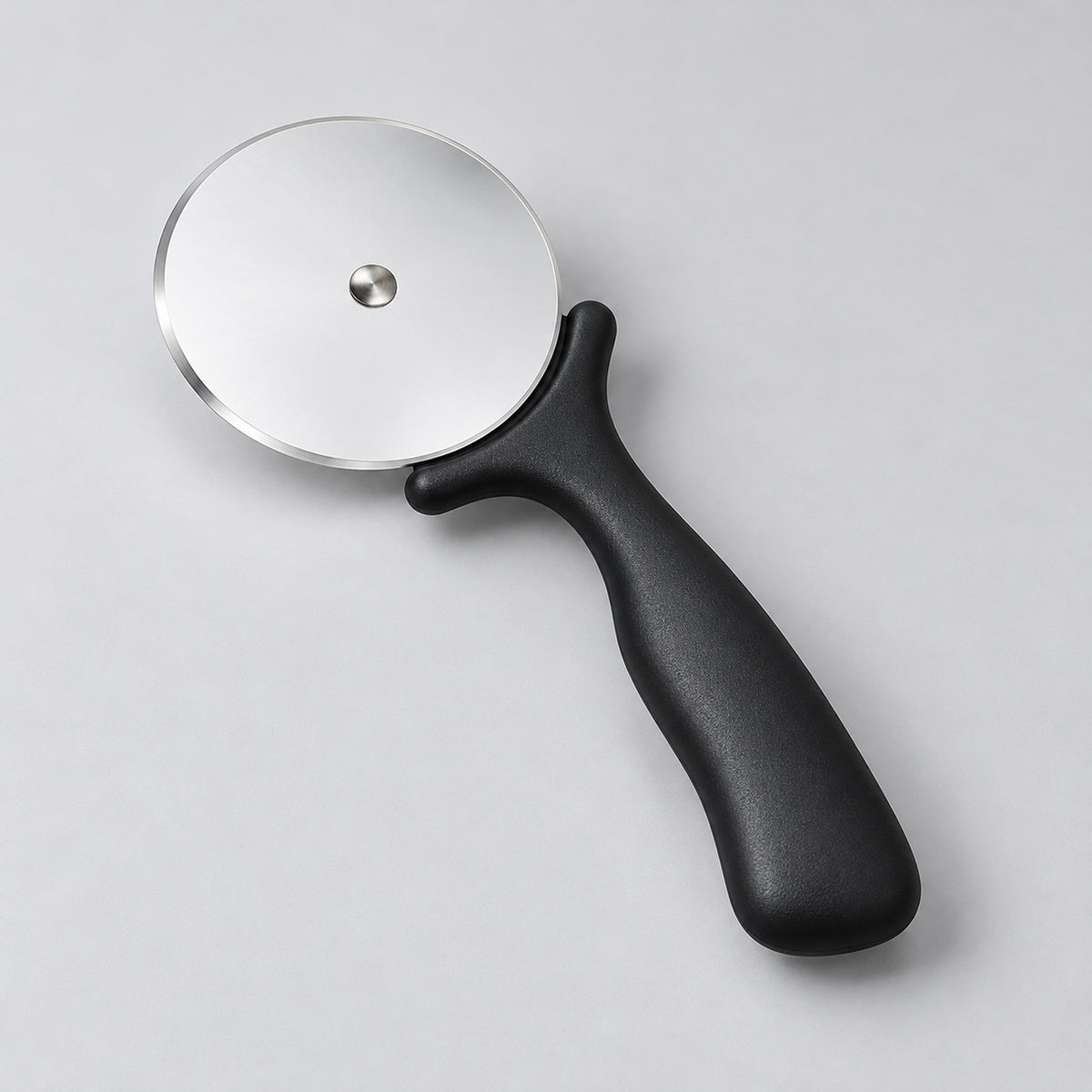 Angled view of the black pizza cutter and thin steel wheel.