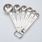 Six empty stainless-steel measuring spoons with capacity marks from 0.6 to 15 ml.