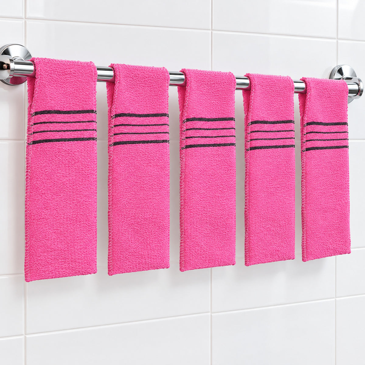 Five pink exfoliating mitts spaced along a bathroom rail between uses.