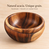 Handmade acacia bowl with unique wood grain and smooth oil-coated finish.