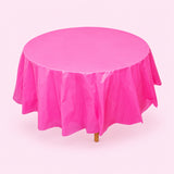 One hot pink disposable PVC tablecloth draped over a round table.