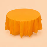 One orange disposable PVC tablecloth draped over a round table.