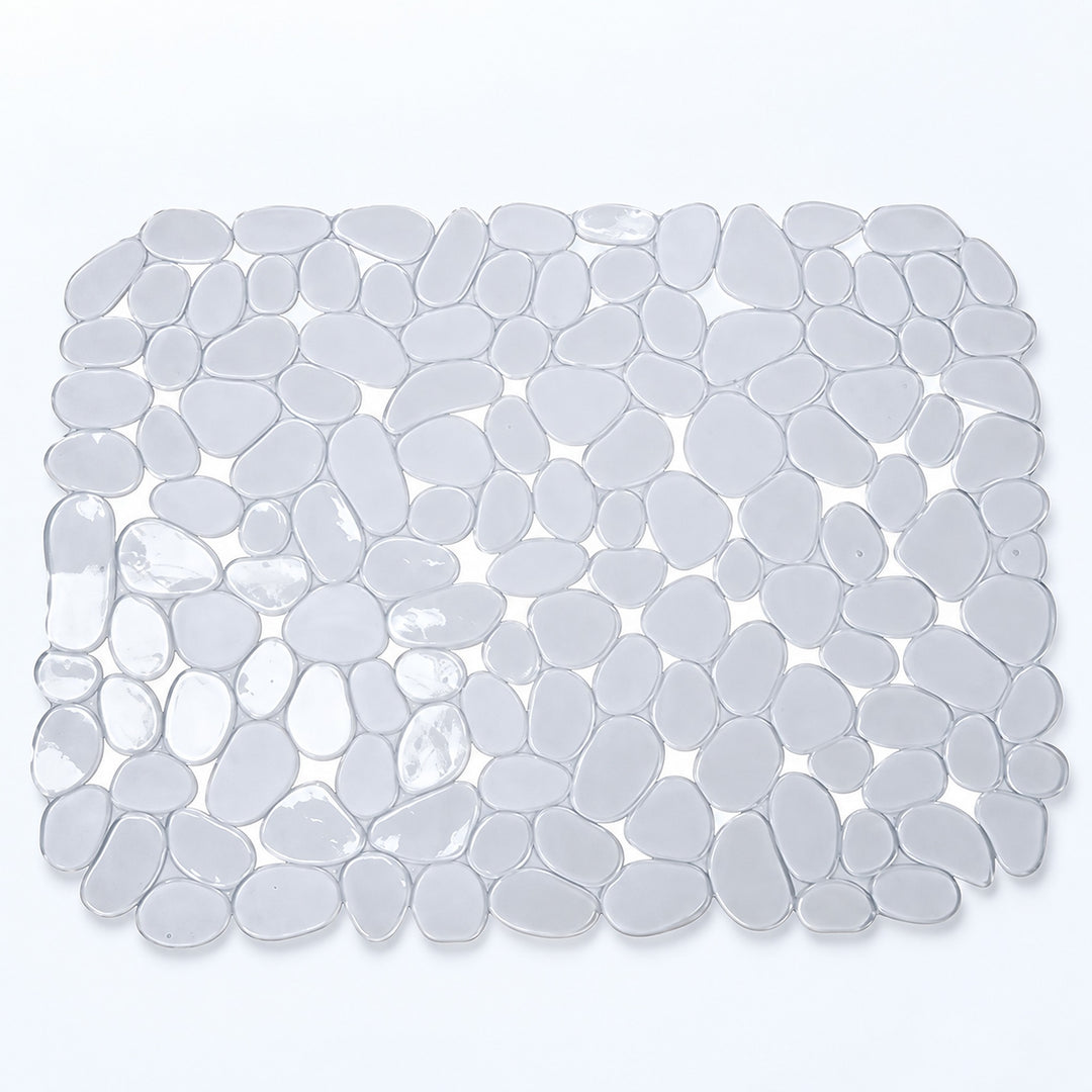 A rectangular bath mat made of smooth, rounded pebble-shaped tiles in translucent white and light gray, shown from a top-down view on a white background.