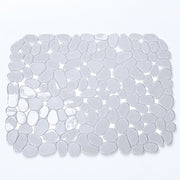 A rectangular bath mat made of smooth, rounded pebble-shaped tiles in translucent white and light gray, shown from a top-down view on a white background.