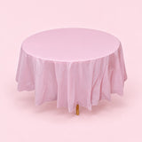 One pink disposable PVC tablecloth draped over a round table.