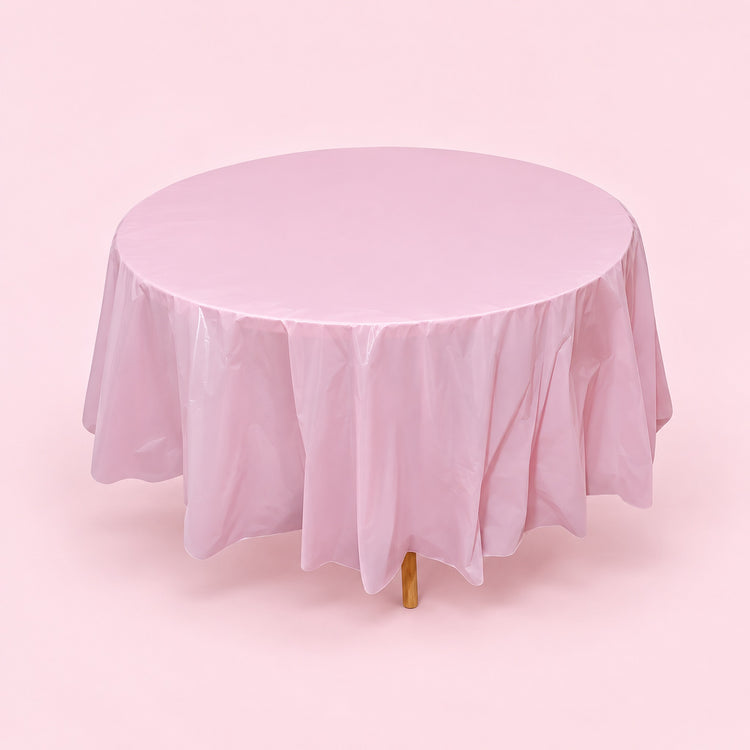 One pink disposable PVC tablecloth draped over a round table.