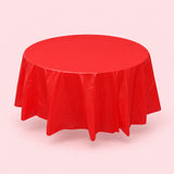 One red disposable PVC tablecloth draped over a round table.