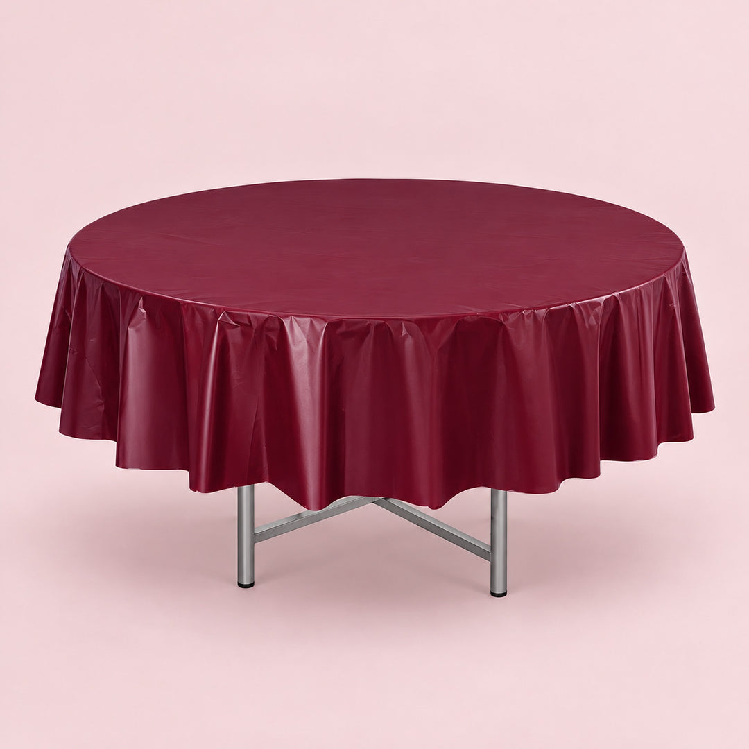 One wine red disposable PVC tablecloth draped over a round table.