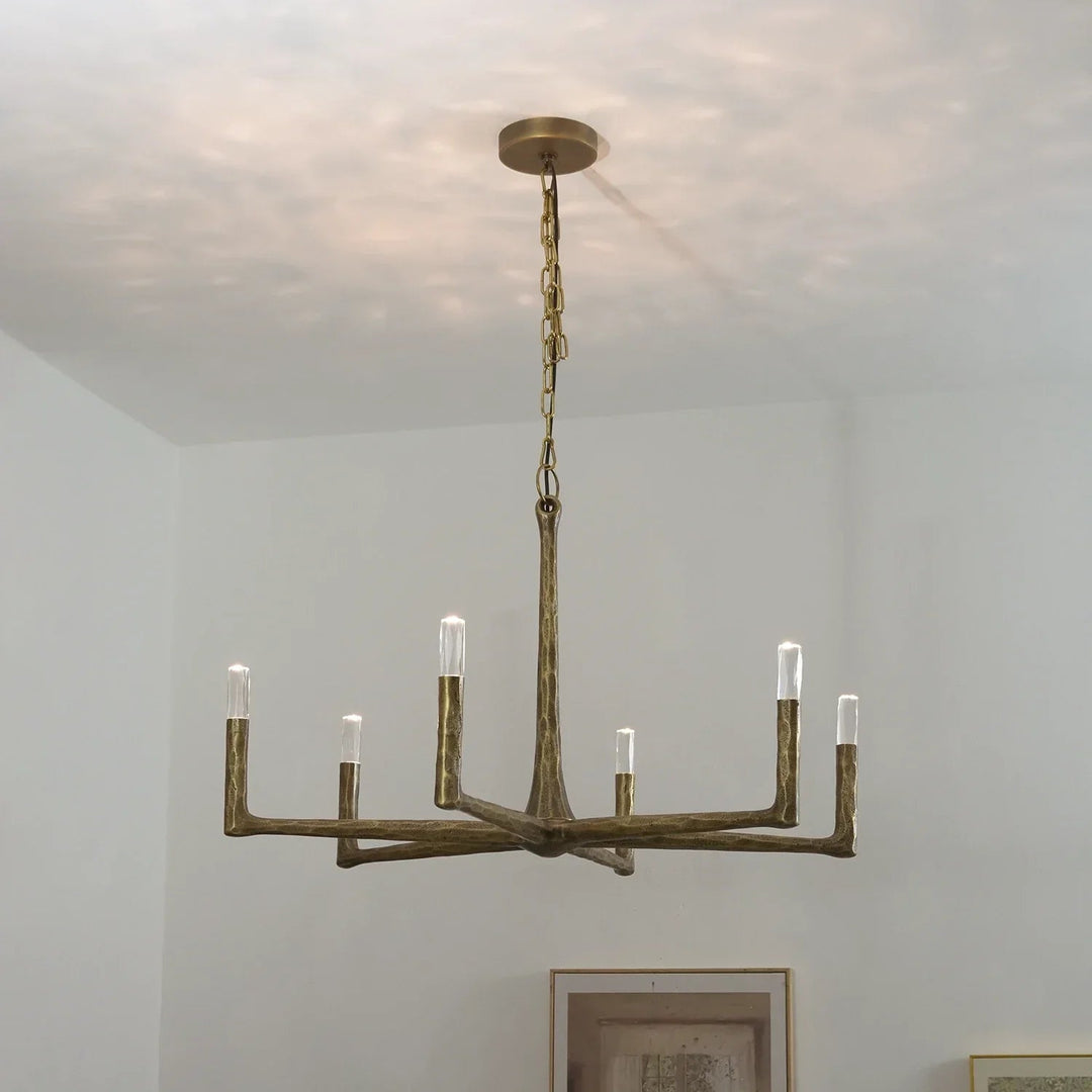 Bronze chandelier hanging from a ceiling with a neutral background