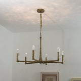 Bronze chandelier hanging from a ceiling with a neutral background