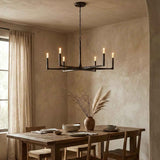Dining room with a rustic wooden table, chairs, and a modern chandelier.