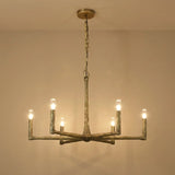 A rustic six-light chandelier with a weathered metal finish, suspended from a ceiling by a chain, shown against a plain beige wall.