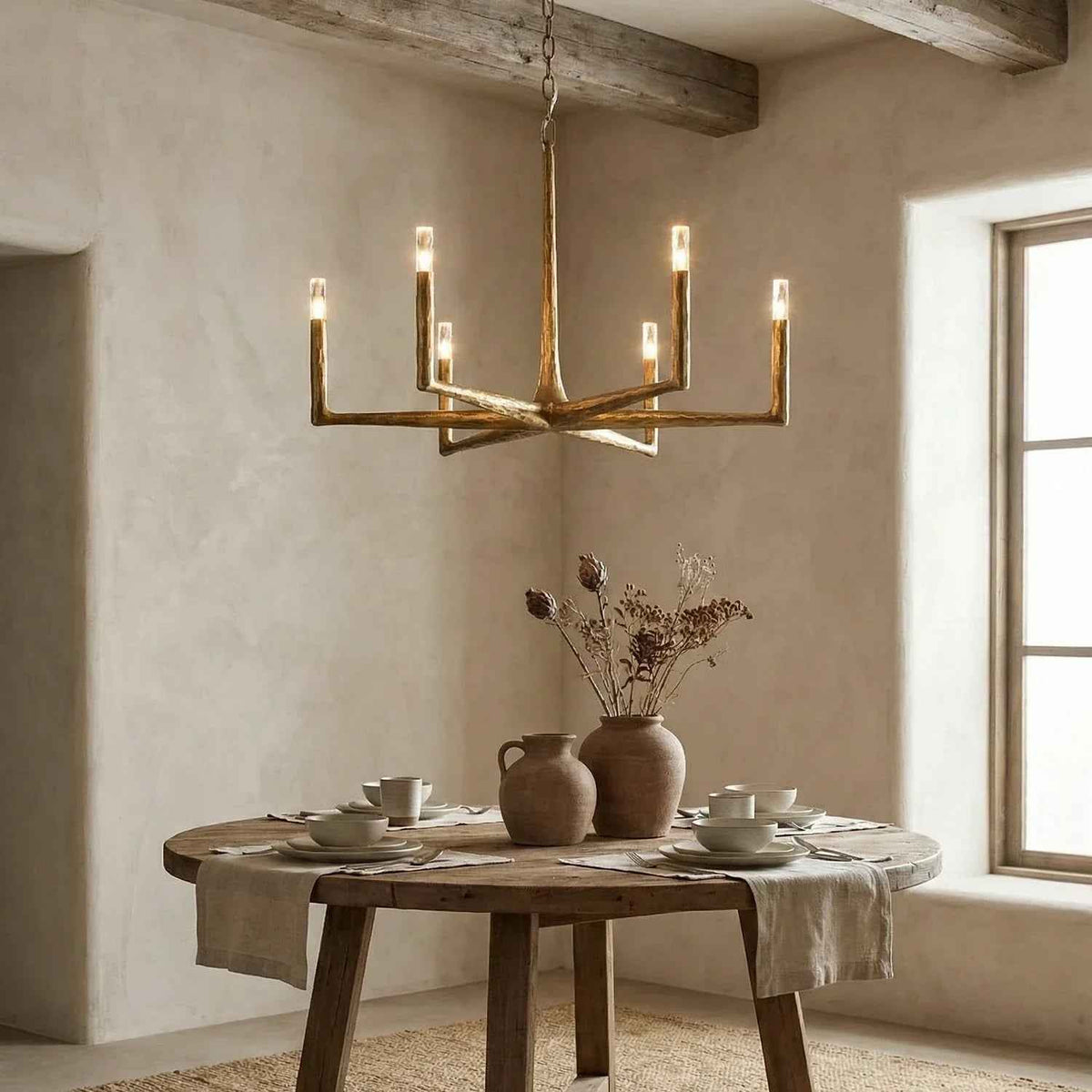Dining room with a rustic chandelier, wooden table, and natural decor.